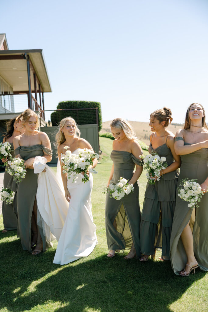 bridesmaids walking on grass laughing