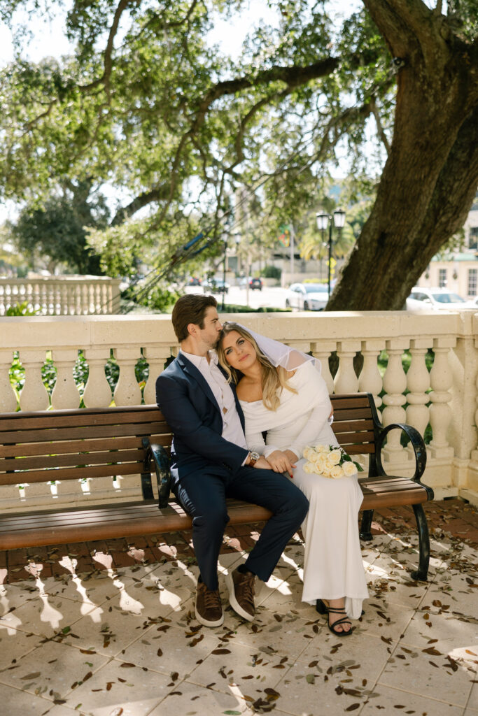 couple sitting on picnic bench snuggling after clearwater courthouse wedding