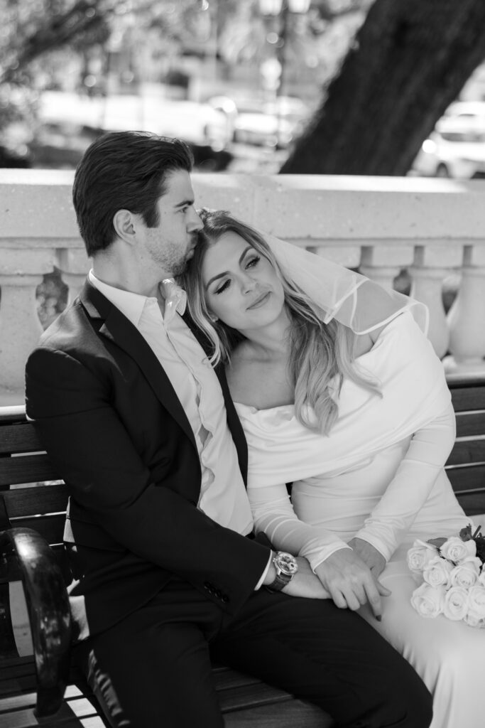 couple sitting on picnic bench snuggling after clearwater courthouse wedding