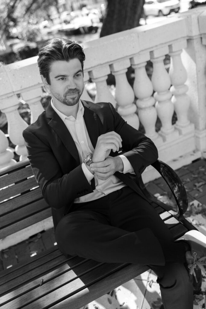 groom sitting on bench adjusting watch