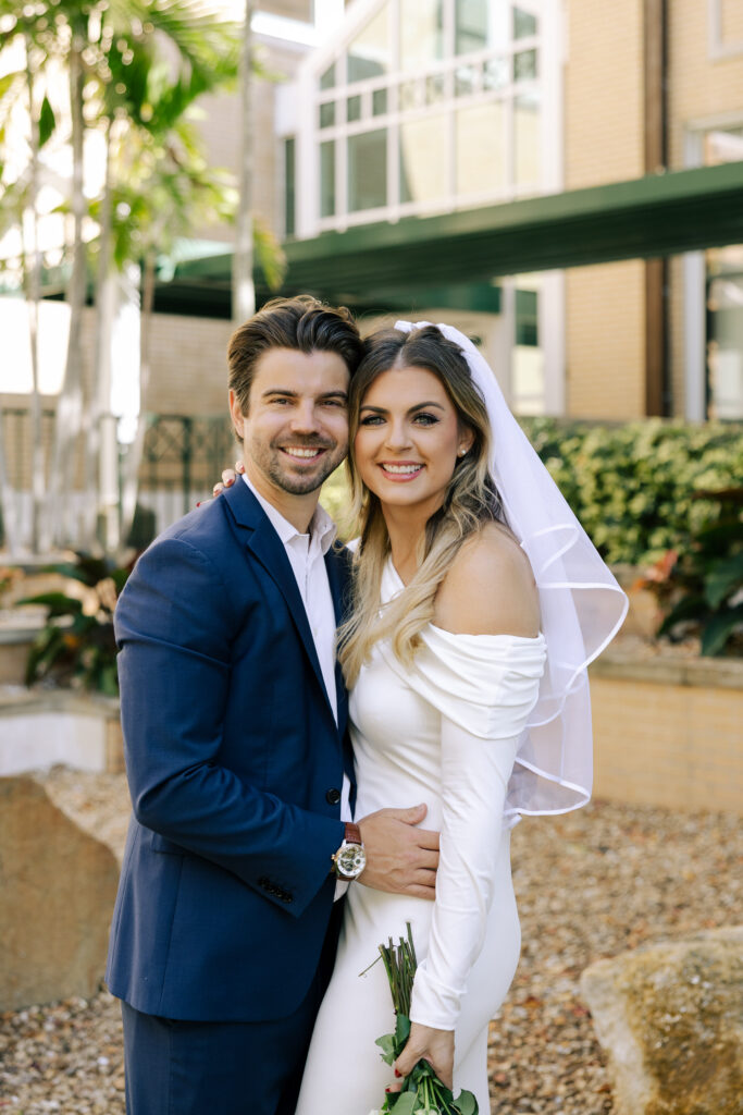 wedding couple in clearwater courthouse courtyard smiling at camera