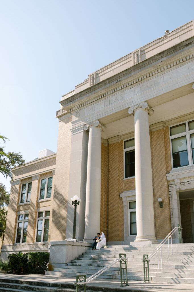 couple sitting on Old Pinellas County Courthouse steps eating cake