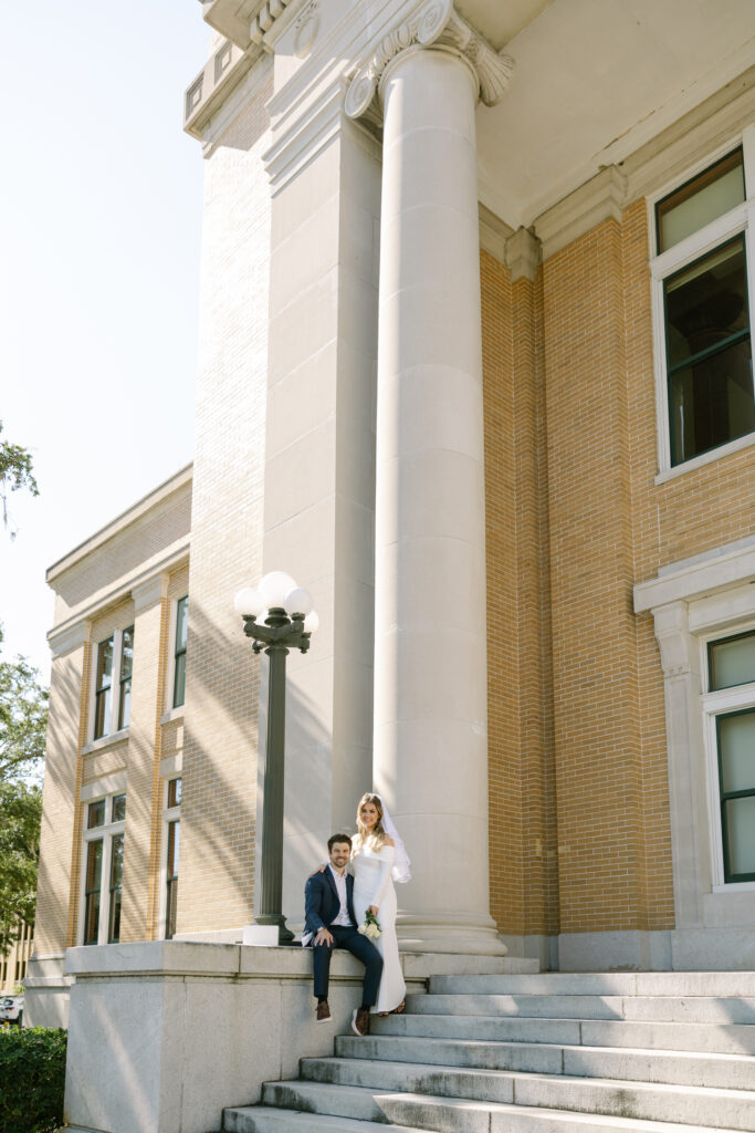 groom sitting and bride standing by Old Pinellas County Courthouse steps