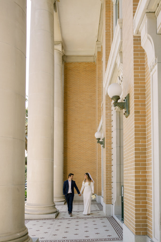 couple walking next to pillars from Old Pinellas County Courthouse