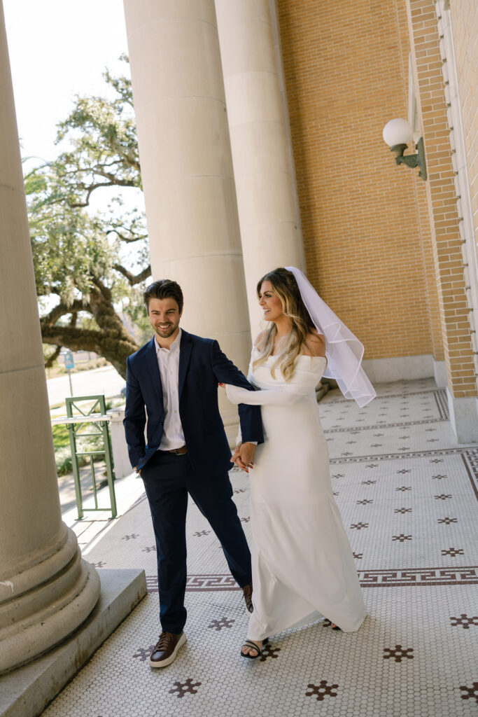 couple walking next to pillars from Old Pinellas County Courthouse